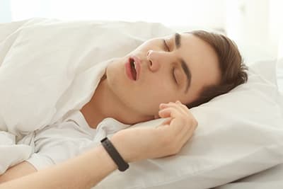 Young man sleeping on back with mouth open