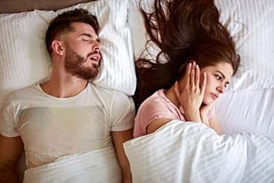 Man snoring keeping his partner awake